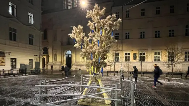 великий дідух - фігурний сніп сіна - в центрі Львова навпроти храму, на фото вечірній Львів