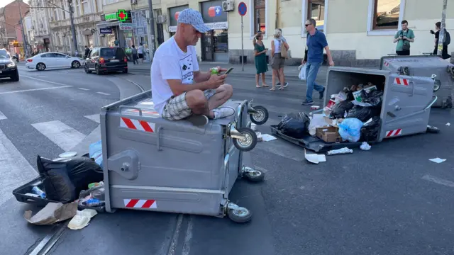 Muškarac sedi na kontejneru