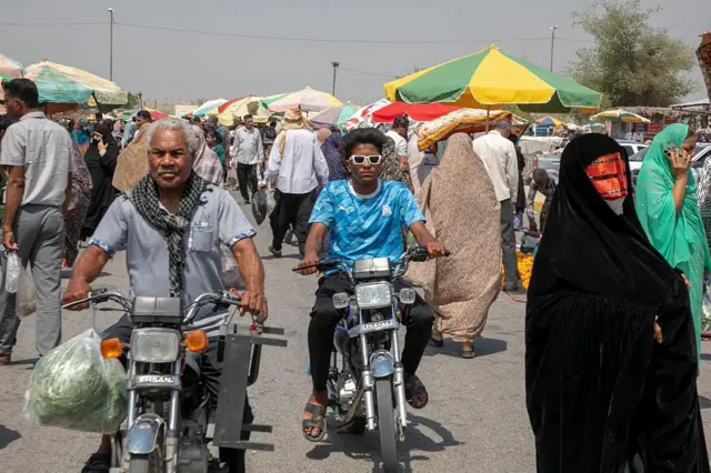 أشخاص يتسوقون في سوق بمدينة ميناب الإيرانية