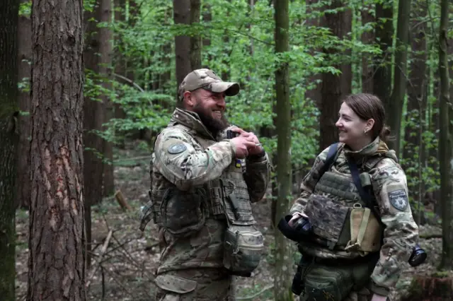 Військовослужбовці бригади "Лють" Національної поліції України сміються перед початком навчань на полігоні в Житомирській області, 23 квітня 2024 року.