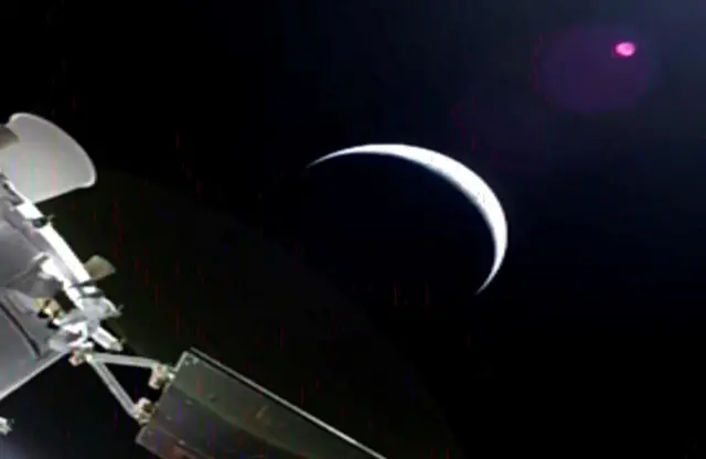 Благо зрнаста слика са Ориона приказује планету - можда Месец, као исечак, вец́и део који је у мраку, и део Ориона у углу.