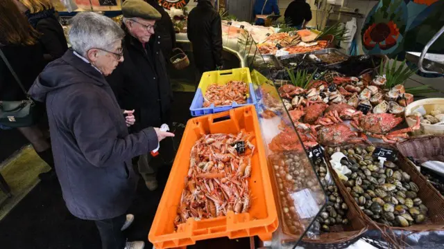 Dos hombres en un mercado de pescado.