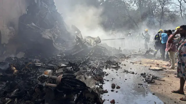 Ljudi stoje i gledaju u mesto gde je pao avion