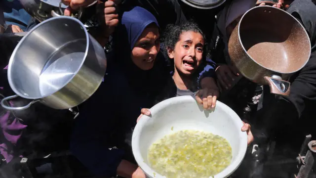 فتاة تبكي بينما ينتظر فلسطينيون الحصول على طعام مطبوخ في مطبخ خيري، في بيت لاهيا