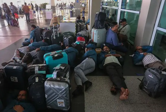 Stranded passengers at airport terminal sleeping on floor