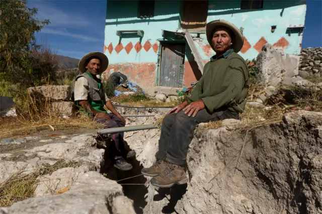 Dos hermanos sentados en los bordes de una grieta.
