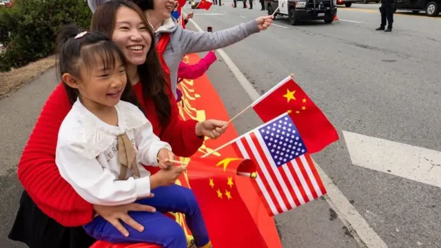 যুক্তরাষ্ট্রে চীনের রাষ্ট্রপতি শি জিনপিংয়ের রাষ্ট্রীয় সফরের সময় একটি শিশু ও তার মা চীনা এবং মার্কিন পতাকা নাড়ছে