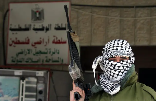 مسلح فلسطيني أمام سلطة أراضي فلسطين في مدينة الخليل في الضفة الغربية المحتلة في 9 فبراير/شباط 2006