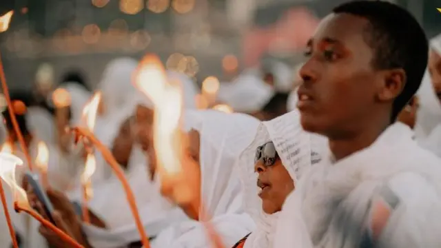 ጧፍ የያዙ ወጣት ወንድ እና ሴቶች