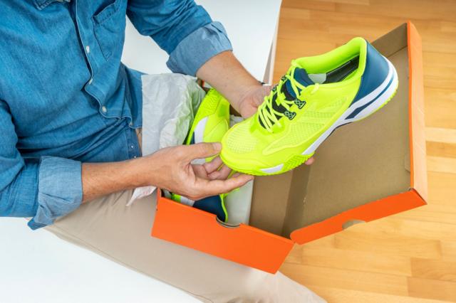 Pessoa tirando tênis de caixa