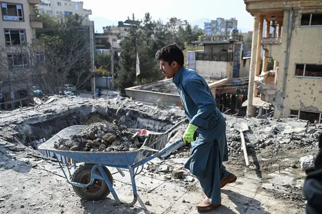 یک مرد در حال بردن آوار در محل حمله هوایی پاکستان در شهر کابل 