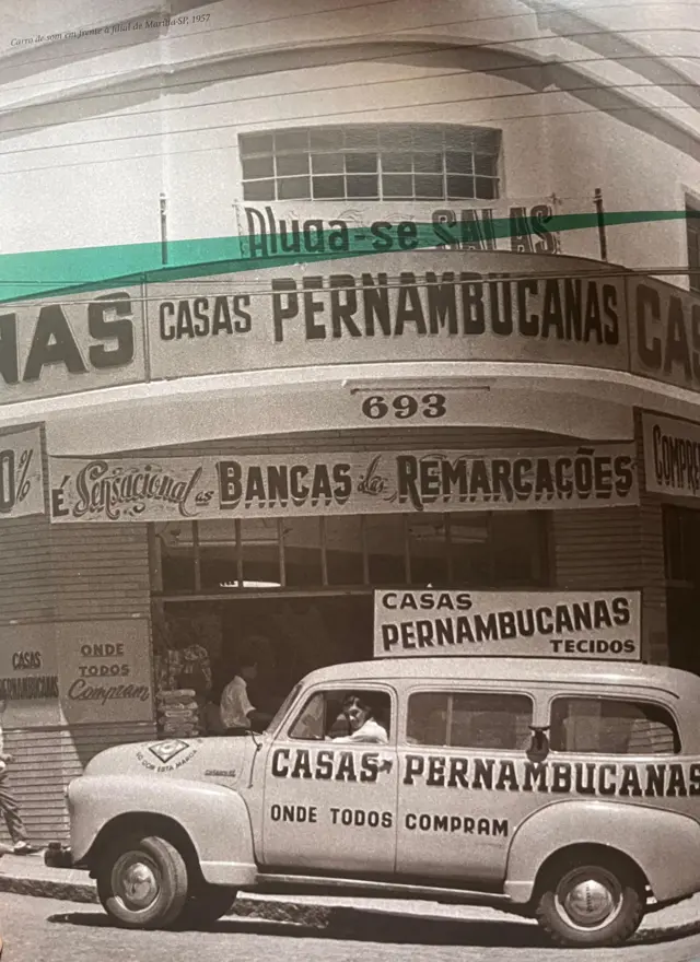 Carro parado em frente a uma loja escrito Casas Pernambucanas