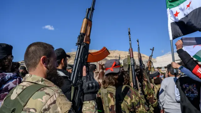 Armed men from Hay'at Tahrir al-Sham in Damascus, on December 13, 2024