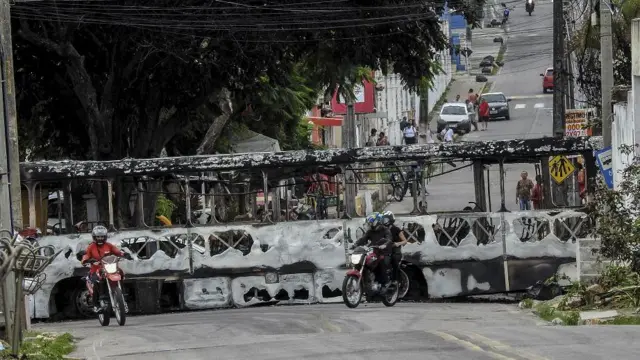 Ônibus queimado ocupando toda a largura da rua