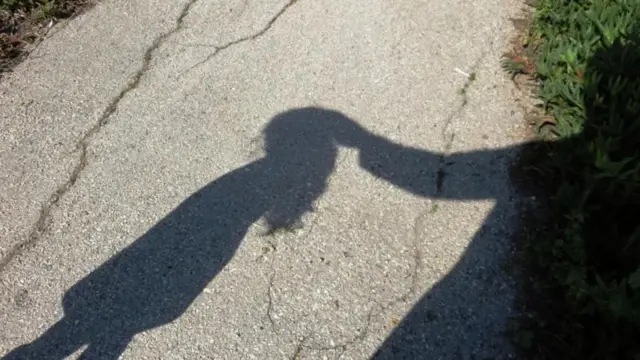 একটি শিশু ও অন্য একজন মানুষের ছায়া, প্রতীকী ছবি