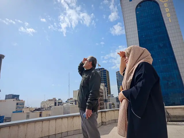 Жителі Тегерана дивляться на небо під час ударів по місту, що тривають.