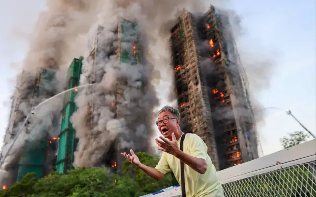 በእሳት ከተያያዙ ህንጻዎች ታች የሚያለቅስ ሰው