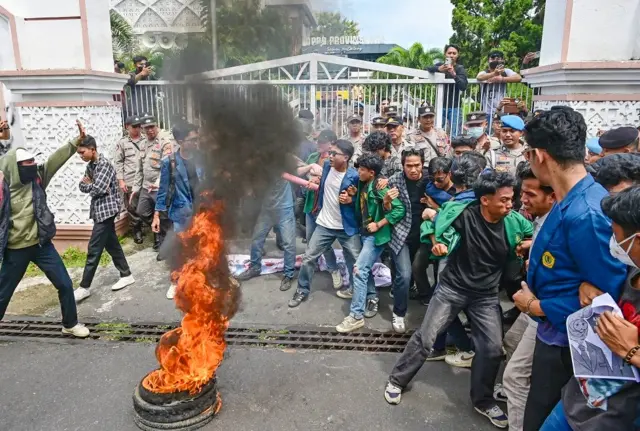 Pengunjuk rasa yang tergabung dalam Aliansi Mahasiswa dan Rakyat NTB membakar ban saat aksi menyikapi UU TNI di depan kantor DPRD NTB di Mataram, NTB, Selasa (25/03).