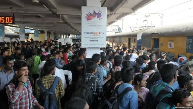 9. Indian passengers wait to board a train bound for coastal districts in the state of Andhra Pradesh at Secunderabad Railway Station in Hyderabad on January 12, 2018. Indian residents are returning to their homes ahead of the Sankranti festival, which will be celebrated on January 13 -16 this year, to mark the begining of the harvest season