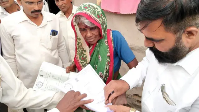 प्रमाणपत्रावर अंगठा उमटवताना शेकूबाई