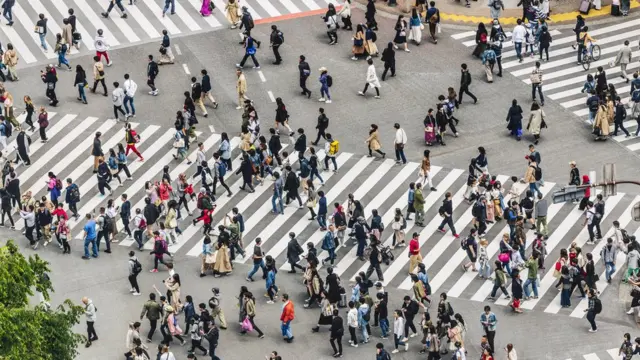 Un cruce de calle repleta de personas.
