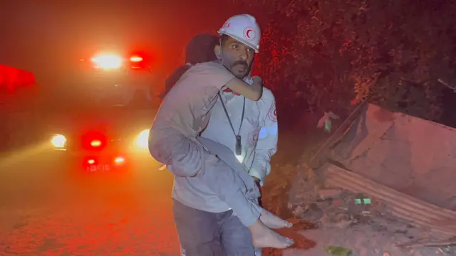 Un paramédico con un niño en brazos