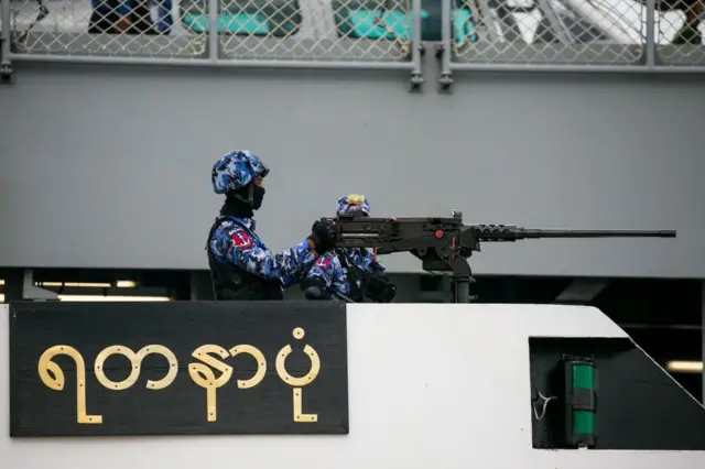A member of the Myanmar navy stands guard during the inauguration of a new military coastguard in Yangon on October 6, 2021. (Photo by STR / AFP) (Photo by STR/AFP via Getty Images)
