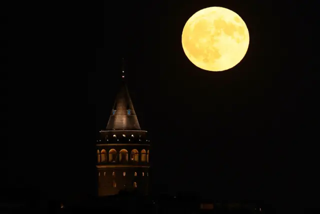 Lua amarelada ao ladouma torre histórica iluminada 