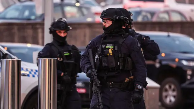 2025-yil 14-dekabr kuni Sidneydagi Bondi plyajida sodir bo'lgan otishmadan keyin voqea joyida qurollangan politsiya xodimlari ishlamoqda.