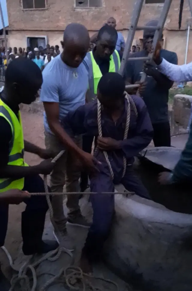 Àwọn òṣìṣẹ́ panápaná tó ń gbìyànjú láti yọ ìyá náà 