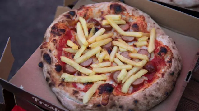 A pizza topped with french fries