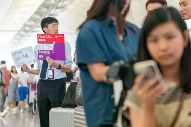 आयटी बिघाड झाल्यानंतर हातात फलक घेऊन उभा असलेला मुलगा 