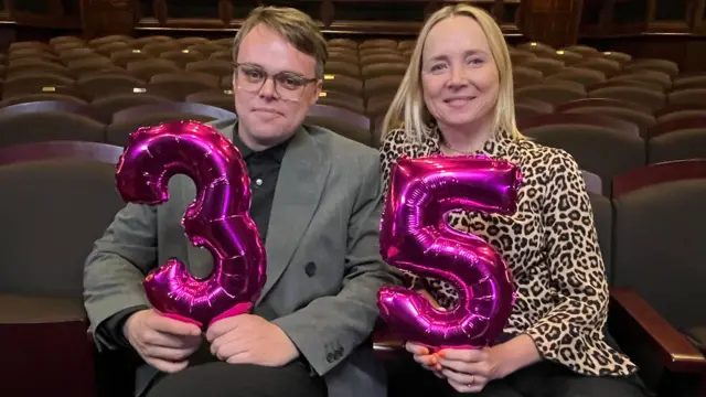 Pasha e a jornalista Katie Razzall, da BBC,  seguram balões que formam 35