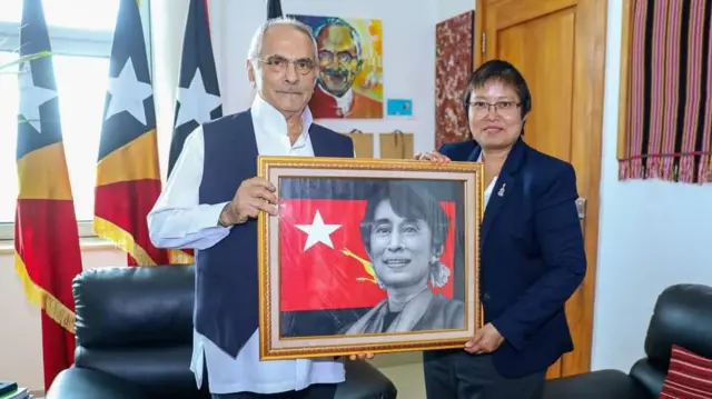 တီမောသမ္မတ ကို ဒေါ်အောင်ဆန်းစုကြည် ပန်းချီကား လက်ဆောင်ပေးနေတဲ့ ဒေါ်ဇင်မာအောင်