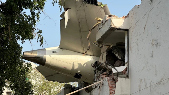 El motor del avión empotrado en un edificio.