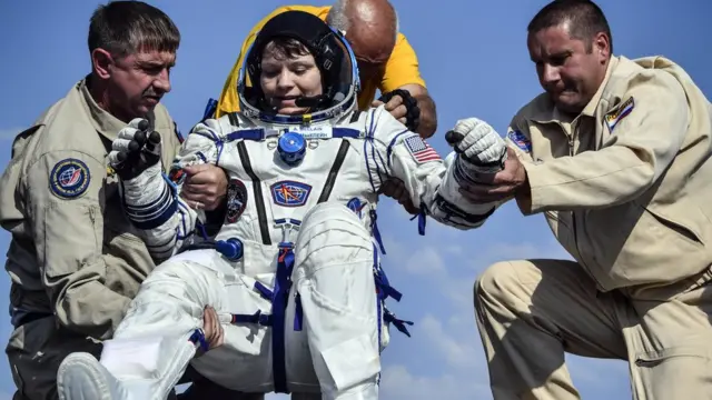 Ground personnel help NASA astronaut Anne McClain to get out of the Soyuz MS-11 capsule shortly after landing in a remote area outside the town of Dzhezkazgan (Zhezkazgan), Kazakhstan, on June 25, 2019.