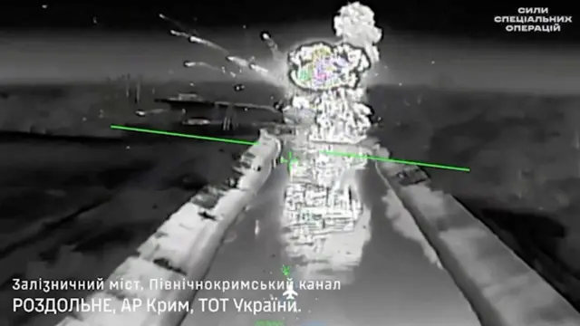 Черно-белая фотография, видимо, с украинского беспилотника, подлетающего к мосту