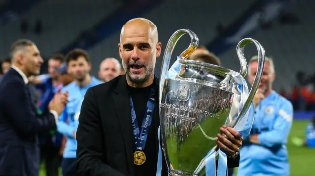 Pep Guardiola Carrying the Champions League trophy
