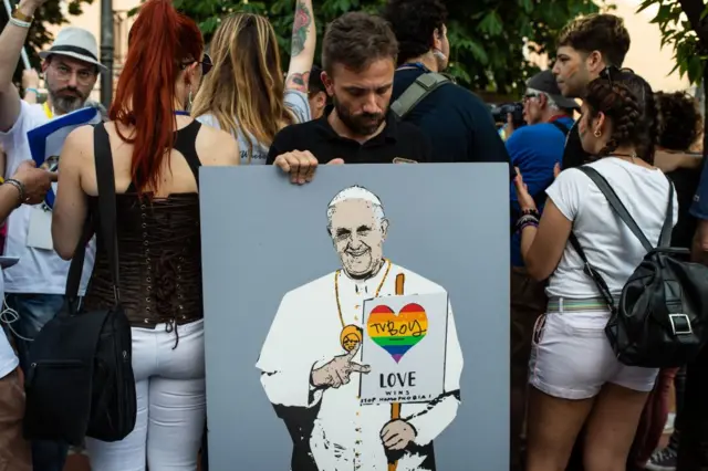 Seorang aktivis LGBT memegang poster bergambar Paus Fransiskus dengan gambar hati berwarna pelangi, dalam acara Avellino Pride 2019, 15 Juni 2019 di Atripalda, Italia.