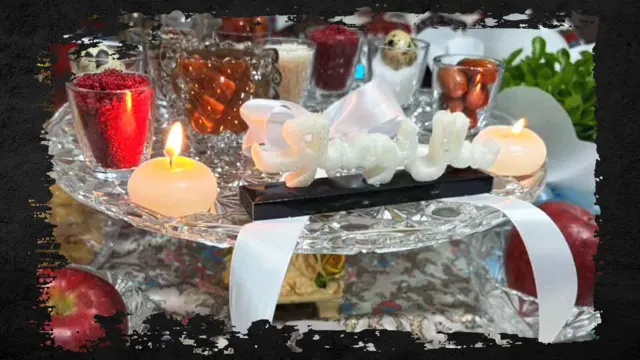 Items gathered together to mark Nowruz, including a candle, a glass containing the spice sumac and a green, leafy plant. The image has had a frame added in the style of distressed black paint.