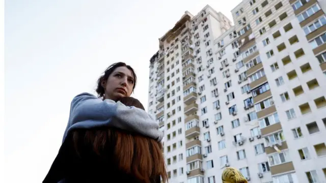 딸을 끌어안고 멍하게 서 있는 여성의 모습