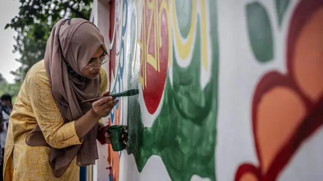 छात्र दीवारों पर नया पेंट कर रहे हैं और नारे लिख रहे हैं. 