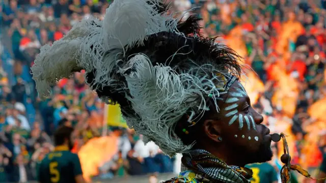 A man in a traditional costume performs ahead of the Rugby test match between South Africa (Springboks) and New Zealand (All Blacks) at Newlands Rugby stadium on October 7, 2017 in Cape Town. / AF