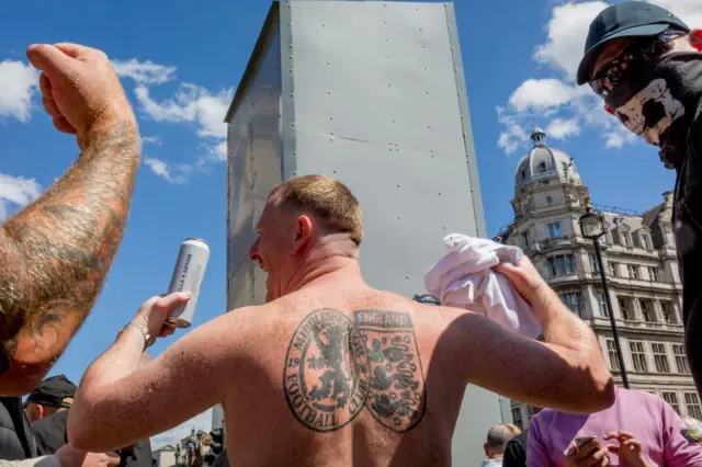 Hombre sin camisa tatuado.