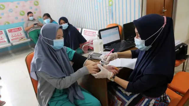 Ilustrasi pelayanan kesehatan. Seorang pekerja kesehatan sedang memerika tekanan daerah seorang pasien. 