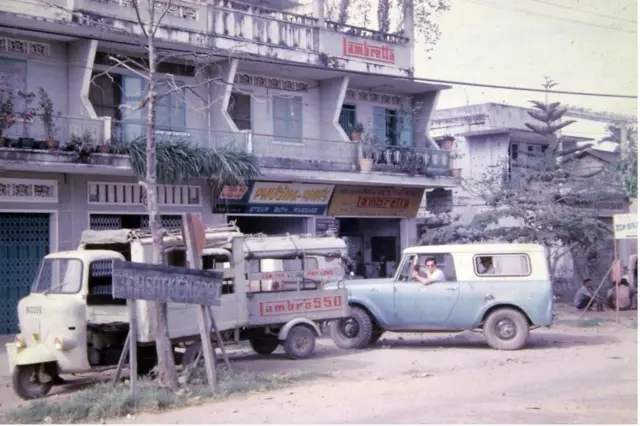 Ông Stephen B. Young ngồi trong xe trước căn hộ (trên tầng hai) mà ông ở khi làm việc tại thành phố Vĩnh Long 