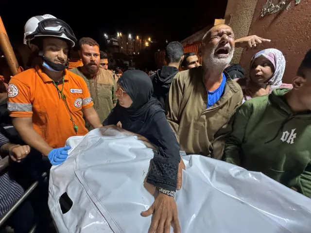 رجل فلسطيني يقف بجانب جثة رجل قُتل في غارة إسرائيلية، وفقًا للمسعفين، في مستشفى ناصر في خان يونس، جنوب قطاع غزة، 28 أكتوبر/تشرين الأول 2025. رويترز/سترينجر صور اليوم.