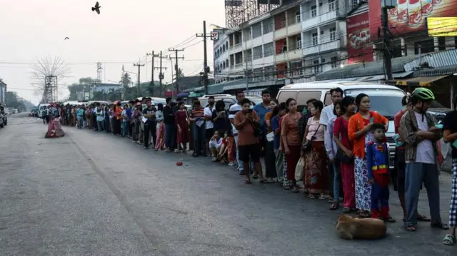 Warga Myanmar mengantri untuk menyeberangi jembatan perbatasan ke Thailand. Pemberontak etnis Myanmar dan milisi sipil mengambil alih kota Myawaddy dari pasukan militer, yang merupakan pusat perdagangan penting dekat perbatasan Thailand.