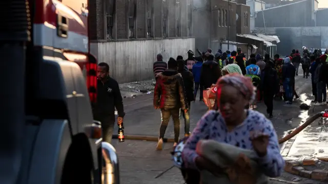 Люди біля будівлі, де почалася пожежа