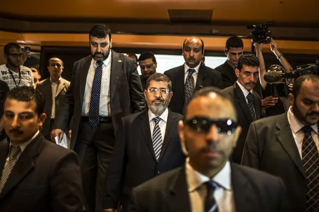 CAIRO, EGYPT - JUNE 13: Egyptian presidential candidate Mohamed Morsi (C) of the Muslim Brotherhood arrives to speak at a press conference on June 13, 2012 in Cairo, Egypt. Egyptian candidates Mohamed Morsi and Ahmed Shafiq are pegged against each other in the second round of voting for the country's president to be held on the 16th and 17th of June. (Photo by Daniel Berehulak/Getty Images)